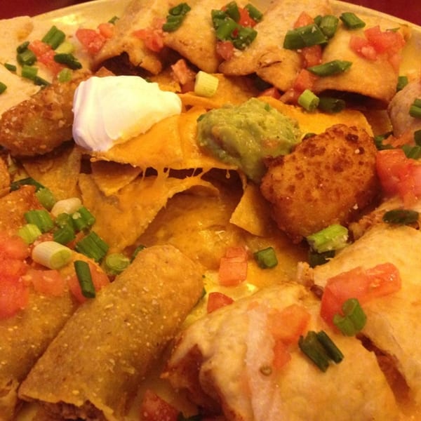 A close-up of Jalisco's Mexican Restaurant's nachos, taquitos, and quesadillas with guacamole and sour cream.
