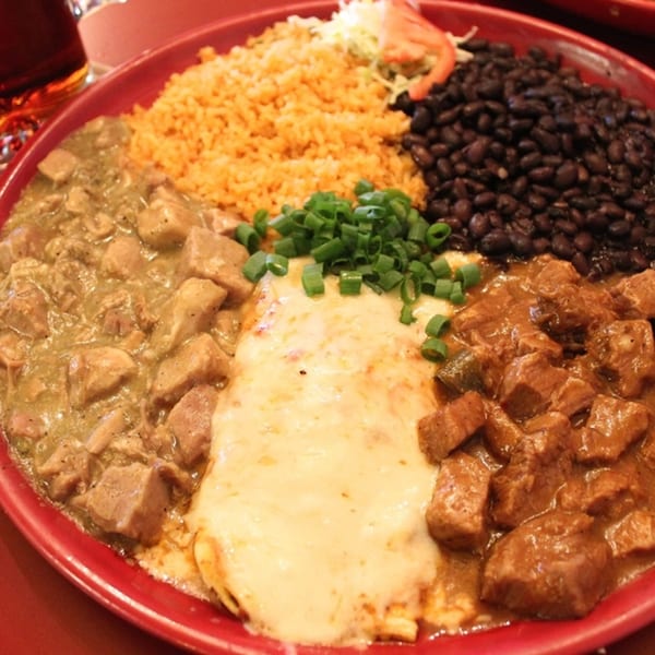 Jalisco's Mexican Restaurant's red plate with rice, black beans, two meat stews, and a cheese enchilada.